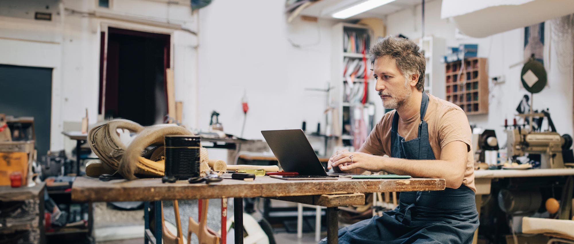 man in the workshop looking at the laptop