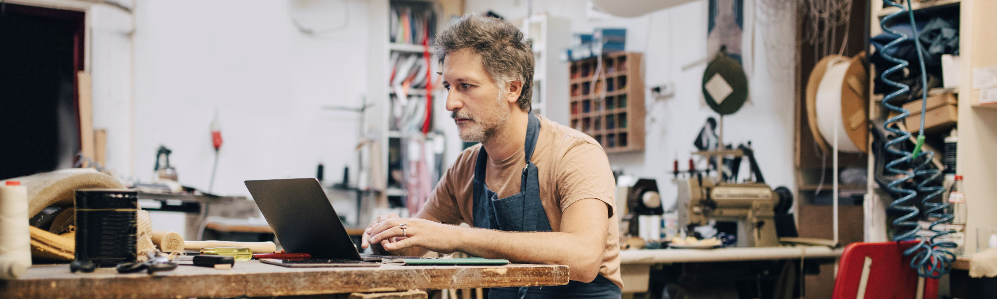 man in the workshop looking at the laptop